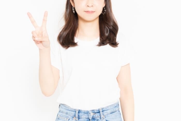 2を指で表している女性